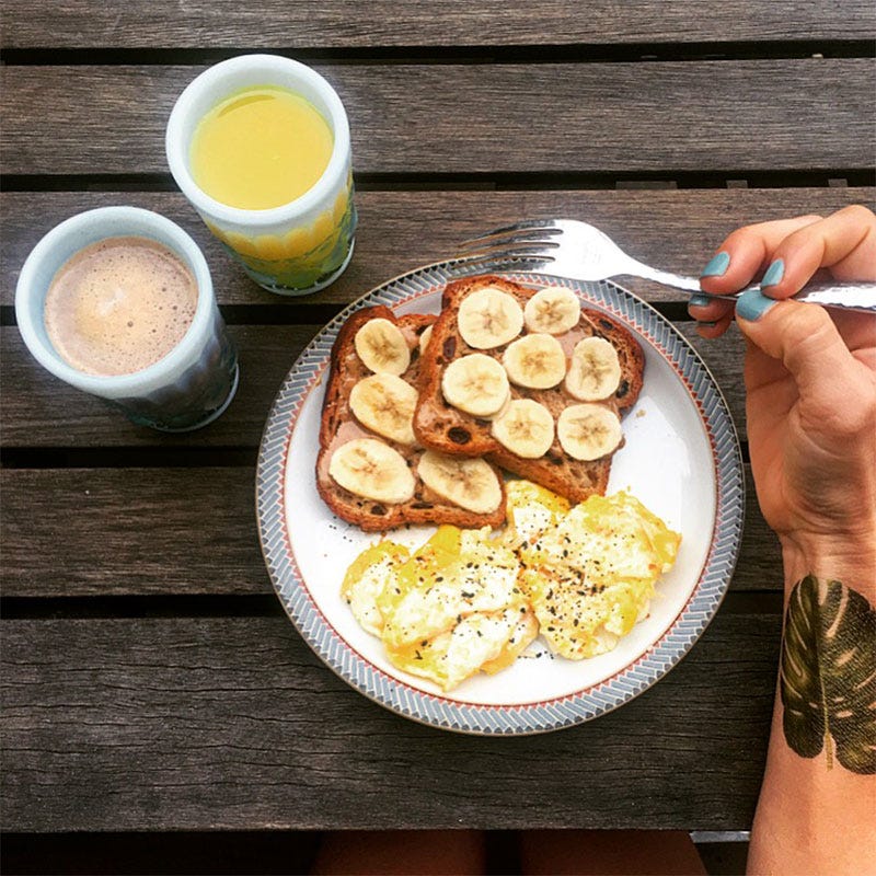 image of orange juice, coffee, eggs, and breakfast items with hand holding fork